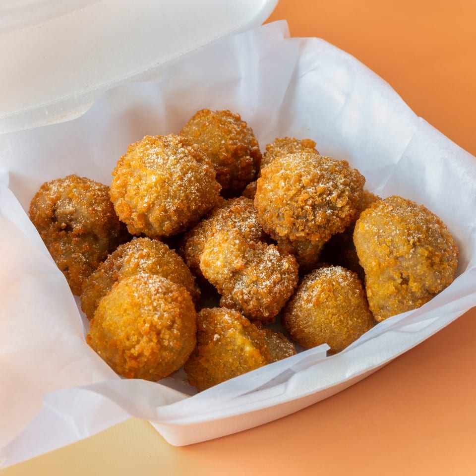 Golden-brown fried seafood bites, likely from Hip Hop Fish and Chicken, served in a white takeout container.